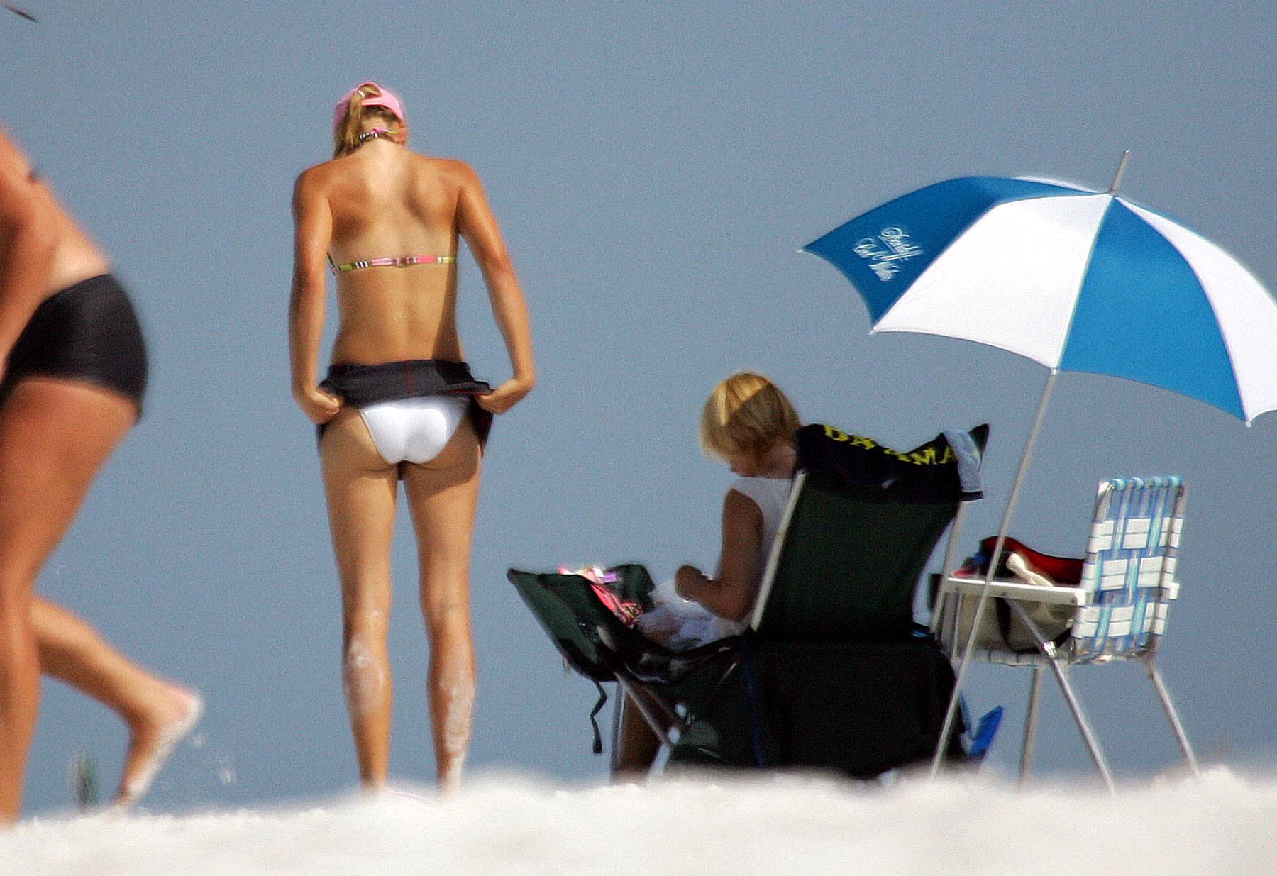 Телочка переодевает купальник в раздевалке на пляже